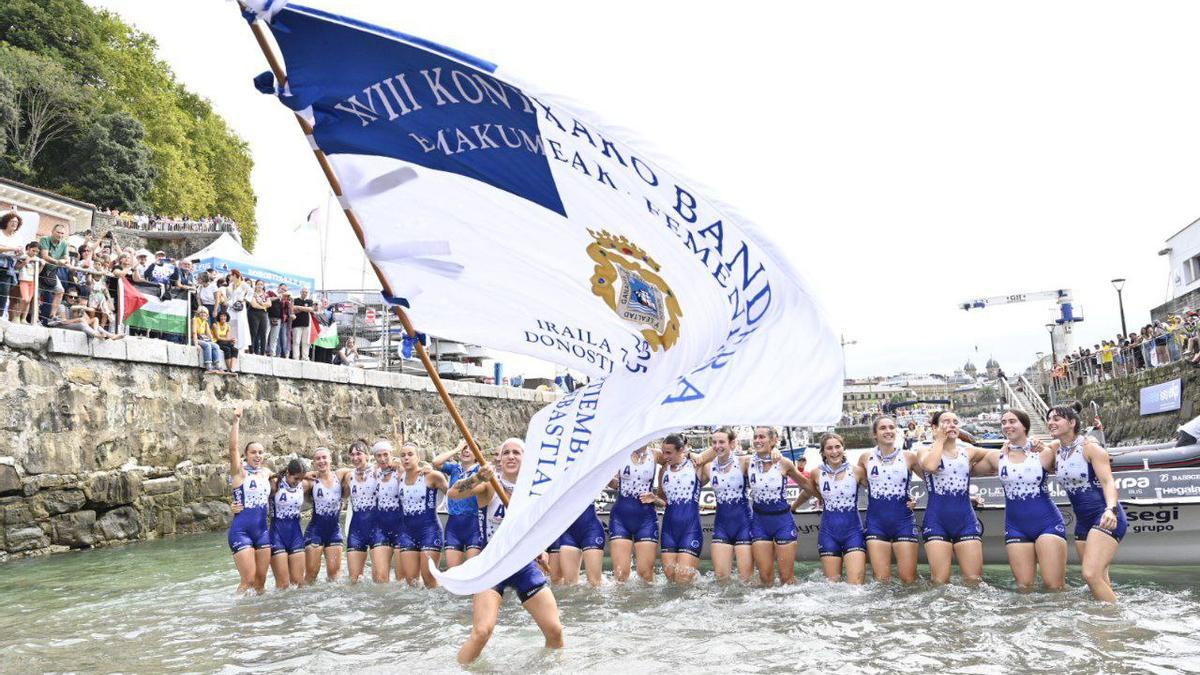 Arraun Lagunak, con la Bandera de La Concha en la rampa del muelle donostiarra.