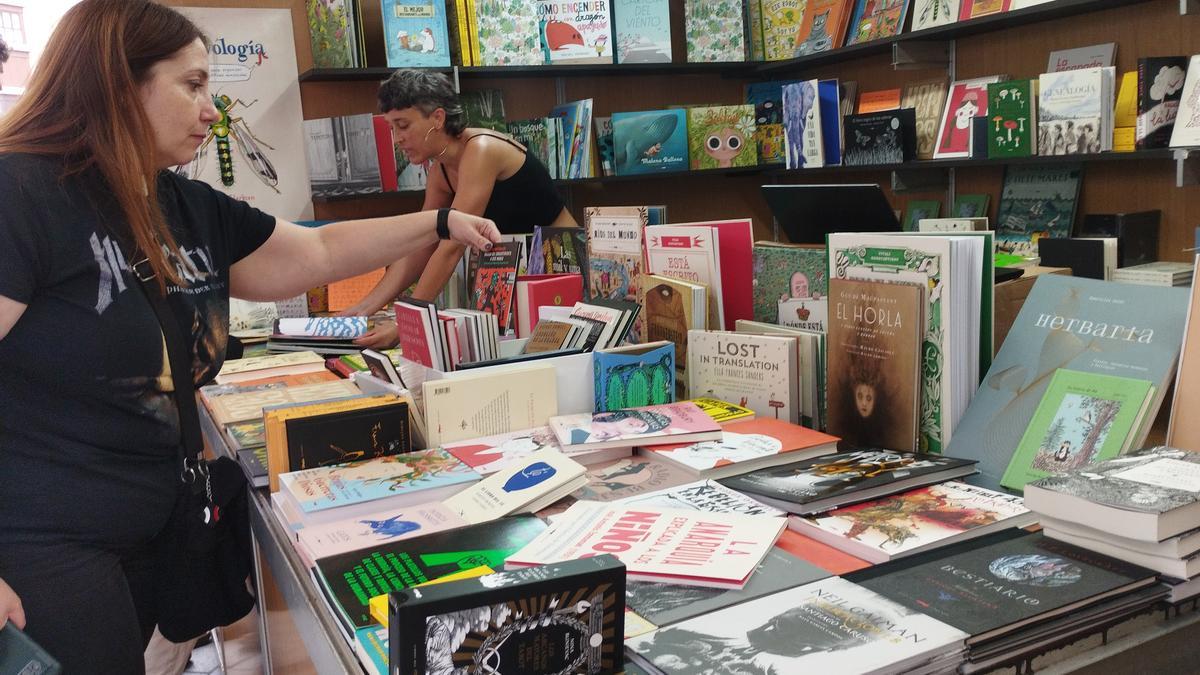 Una de las asistentes al salón consulta un cómic en uno de los puestos.