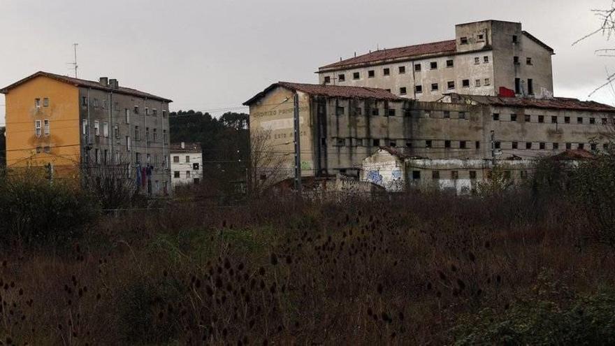 Vista del bloque de viviendas del número 24 de la avenida Aróstegui, en mal estado y problemas de insalubridad, junto a la abandonada fábrica de Argal.