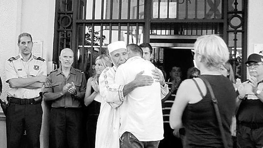 El padre de un niño fallecido en la masacre, con un imán.