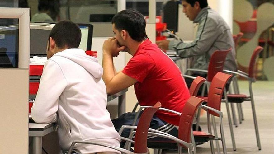 Varias personas haciendo consultas en la oficina de Paulino Caballero del Servicio Navarro de Empleo.