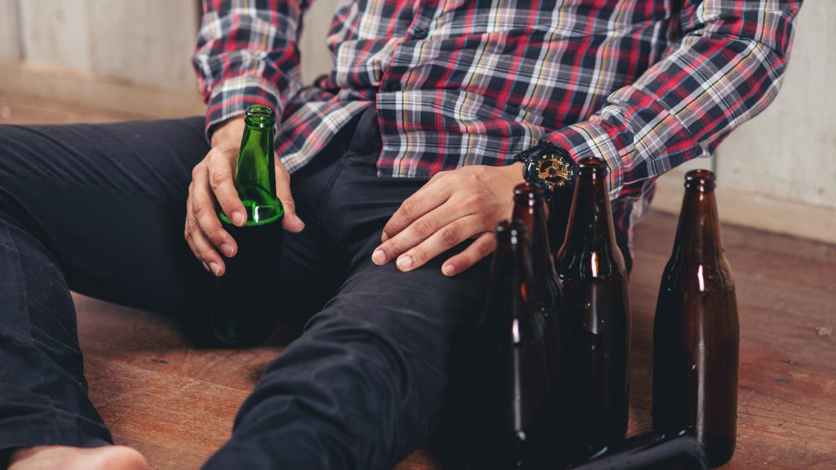 Hombre con botellas de alcohol.