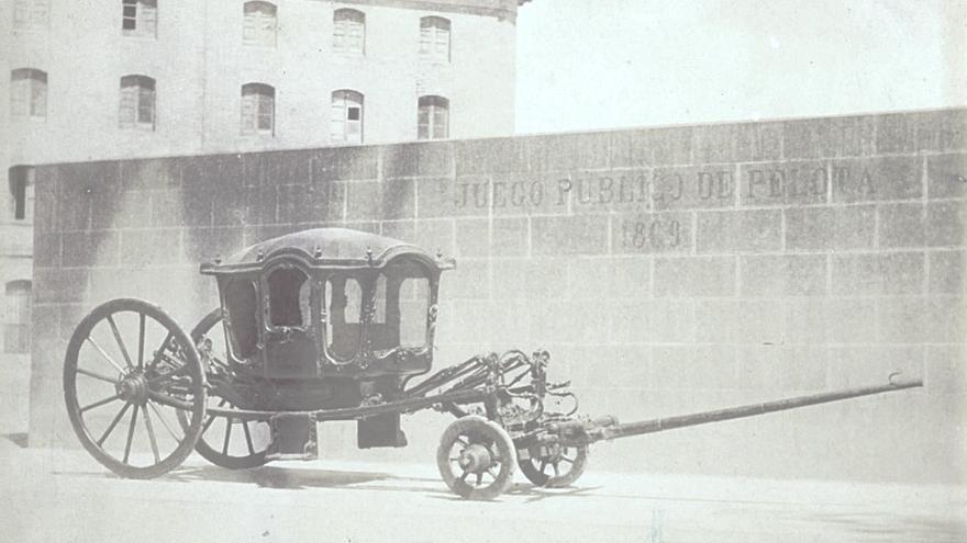 Una carroza delante del rebote del Juego Público de Pelota en 1880. Detrás, el edificio del Vínculo.