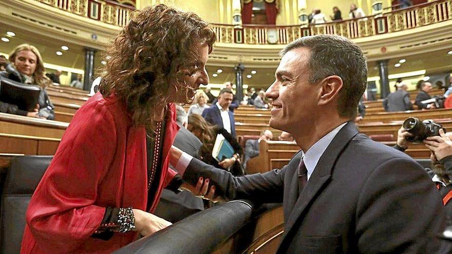 El presidente del Gobierno español, Pedro Sánchez, saluda a María Jesús Montero, ministra de Hacienda, en la bancada azul del Congreso antes de un pleno. Foto: Efe