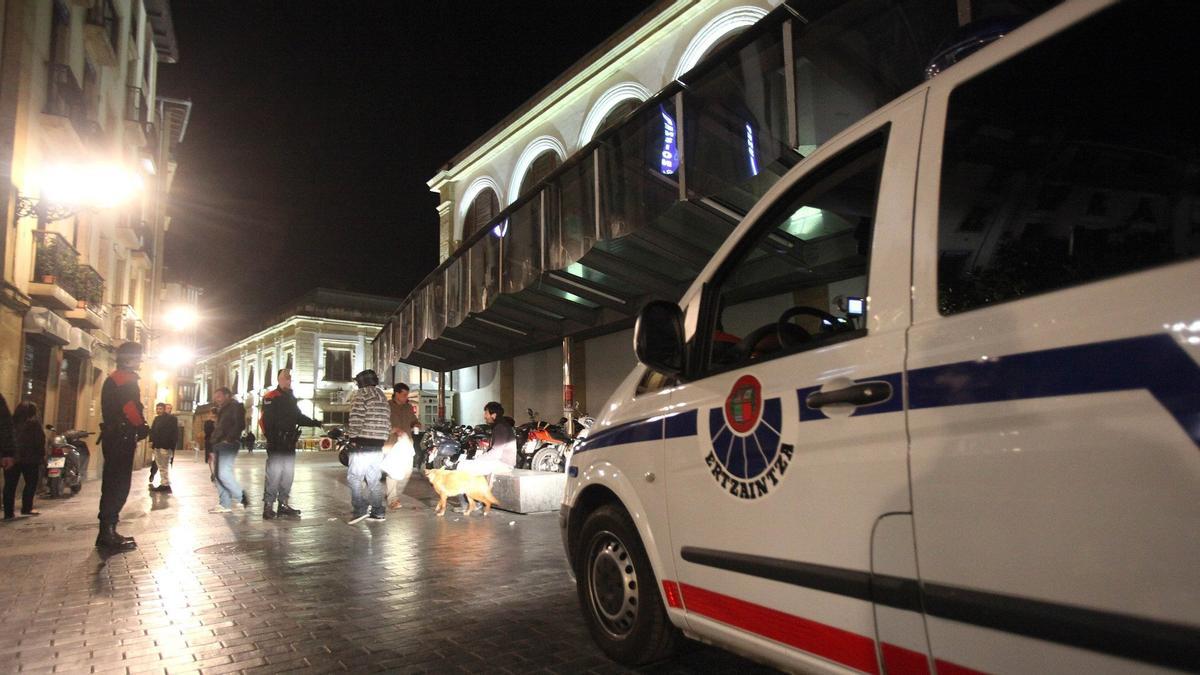 Ertzainas de una patrulla de seguridad ciudadana, junto a una furgoneta policial, patrullando por la Parte Vieja.