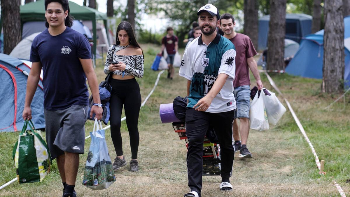 Personas instalándose en la zona de acampada.