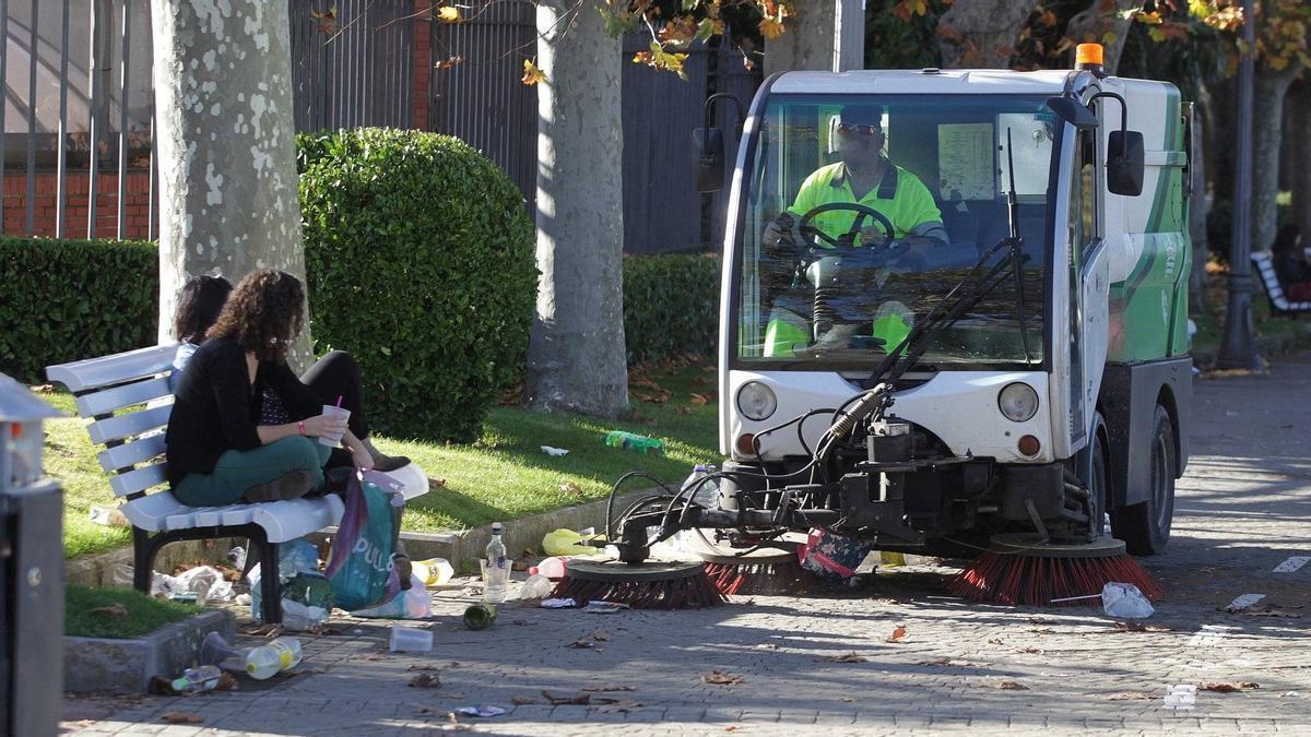 Imagen de archivo de un trabajador limpiando en el marco de un botellón por una carpa universitaria