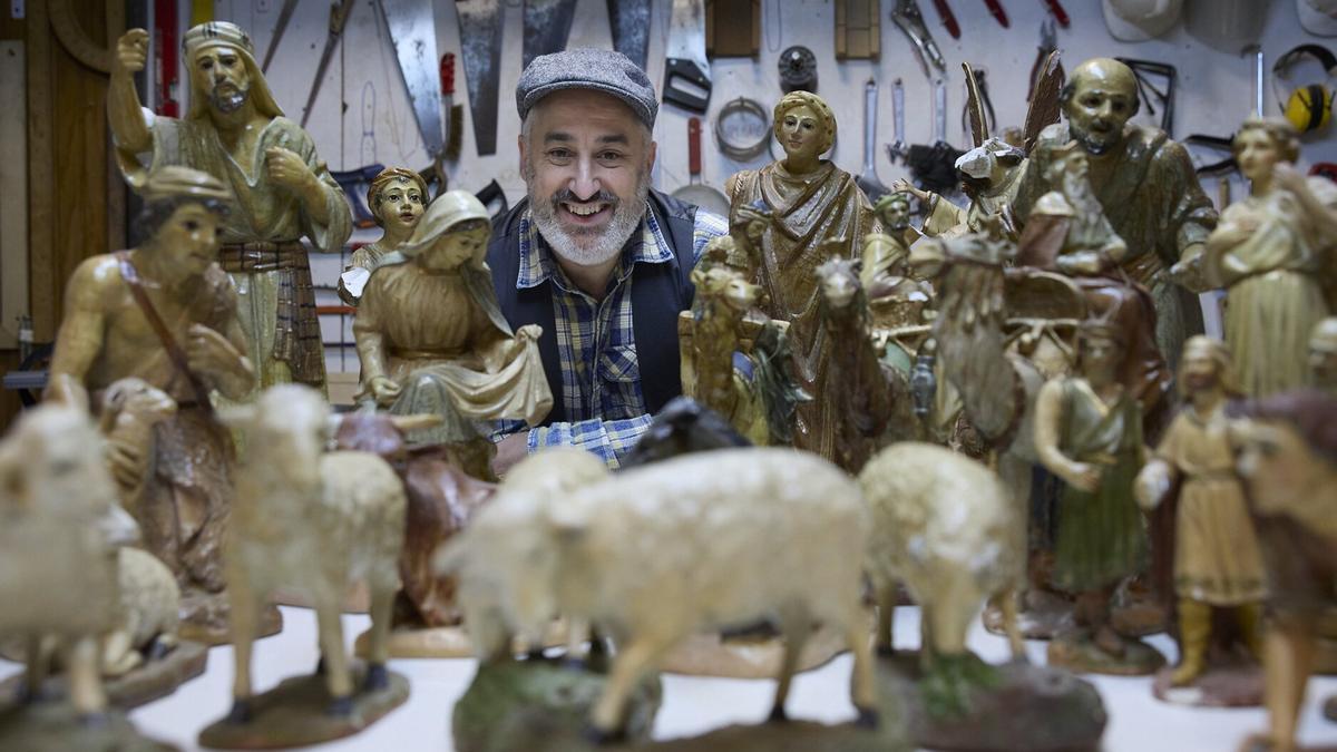 Aitor Ortiz de Felipe posa con las figuras recuperadas del primer belén social de la ciudad en la sede de la Asociación de Belenistas de Pamplona.