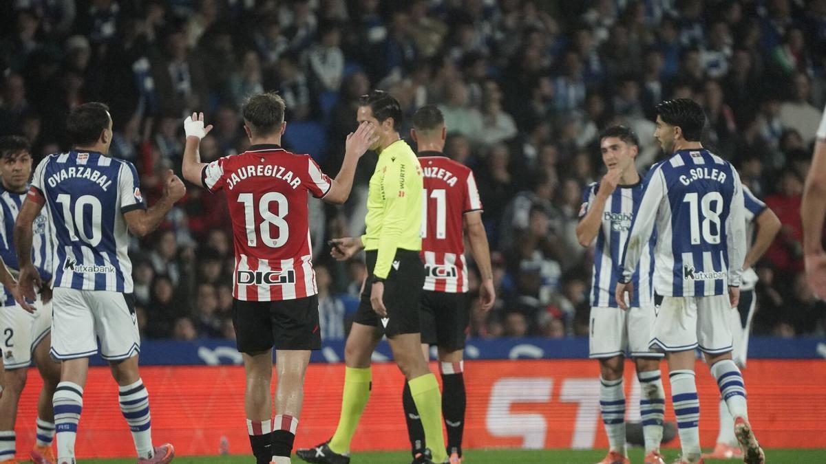 Munuera Montero, rodeado de jugadores de ambos equipos en el derbi.