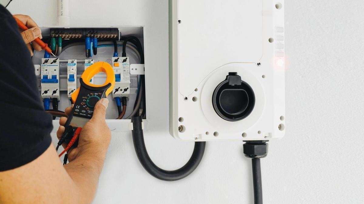Tecnico comprobando instalación de punto de carga de coche eléctrico