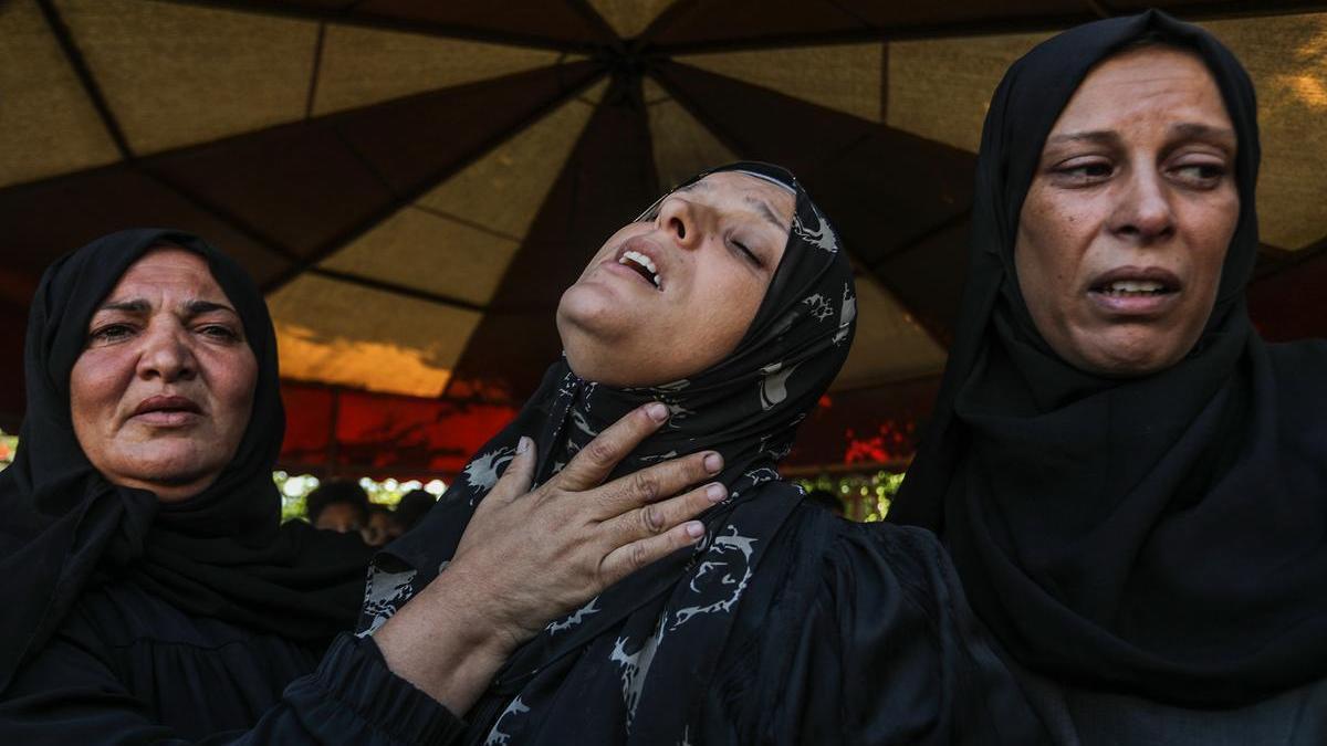 Tres mujeres lloran por la muerte de un familiar tras un ataque israelí después del alto el fuego.