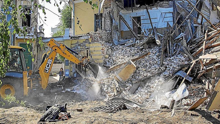 Una excavadora retira los escombros de una casa atacada por las tropas rusas en Járkov.  | FOTO: EFE