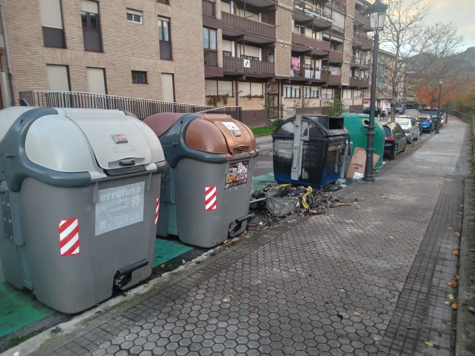 Actos vandálicos en Lazkao: contenedores quemados y pintada en el frontón