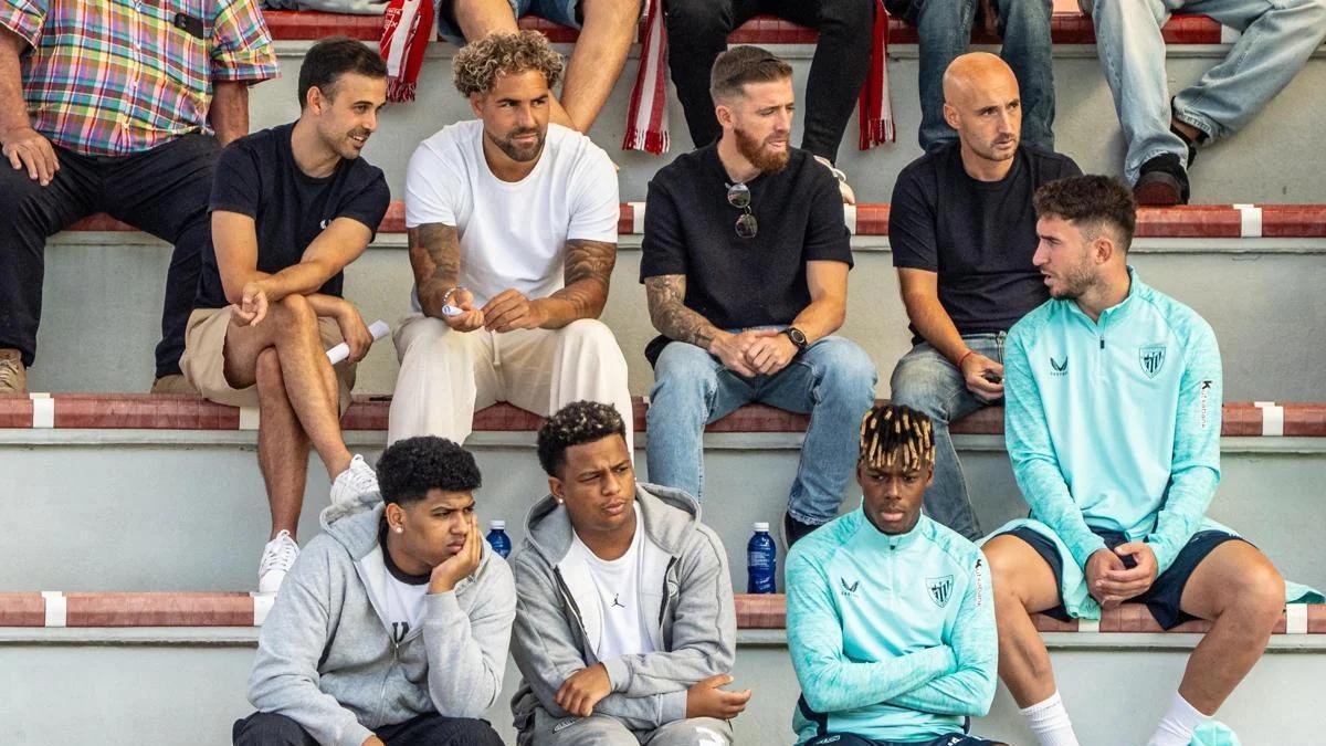 Nico Williams, Aymeric Laporte e Iker Muniain, en la grada del Campo 2 de Lezama para ver al Athletic juvenil en la Youth League.