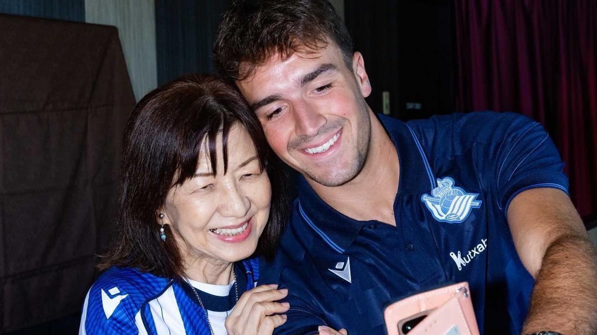 El jugador de la Real Luken Beitia se fotografía con una seguidora de la peña Reala Nippon en Nagasaki