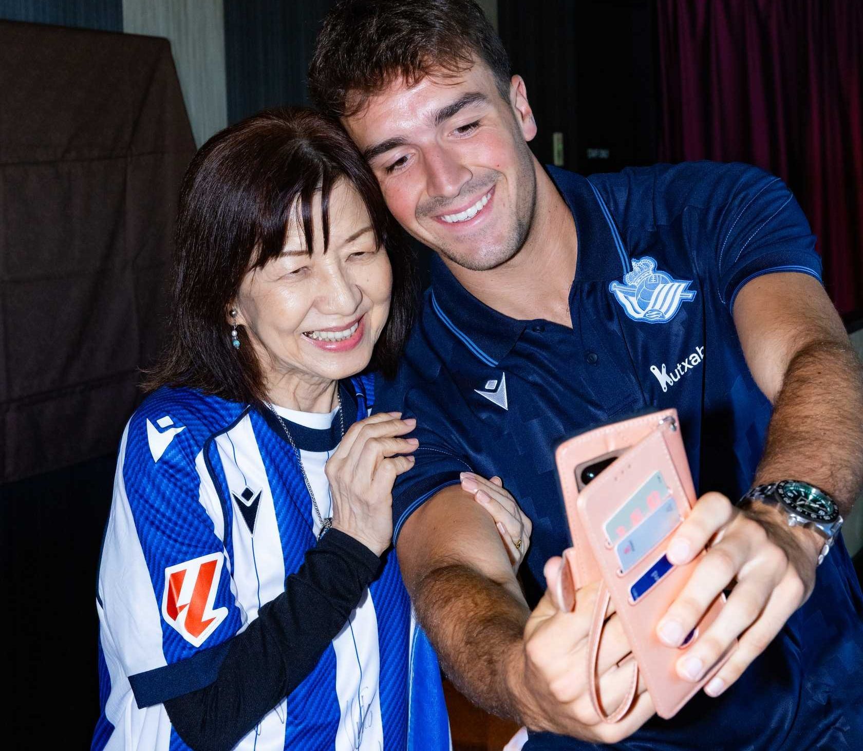 El jugador de la Real Luken Beitia se fotografía con una seguidora de la peña Reala Nippon en Nagasaki
