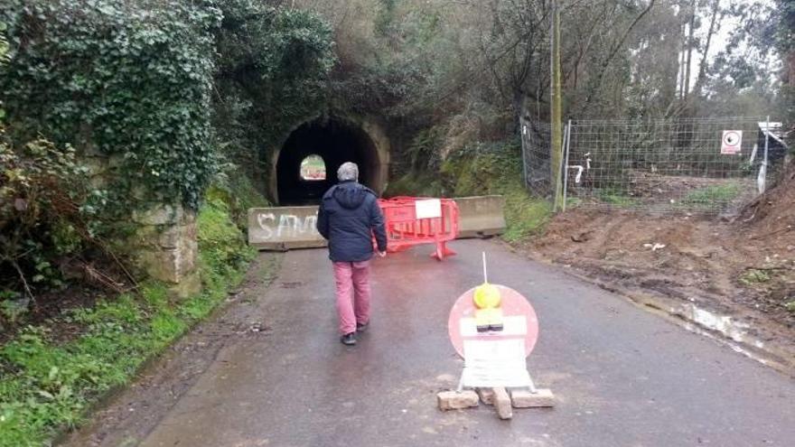 Un vecino se acerca para leer la advertencia municipal sobre le cierre del túnel.