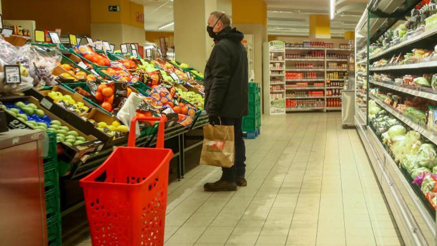 Un hombre en la sección de frutería de un supermercado