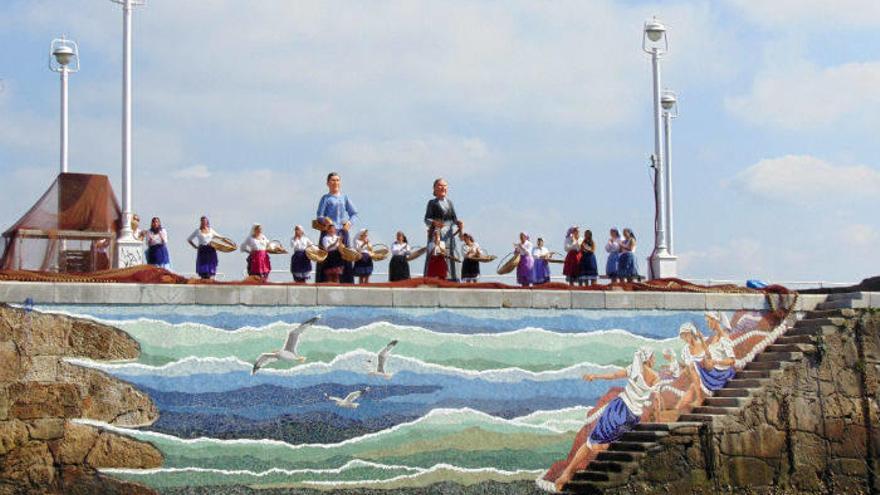 Un grupo de mujeres fue el encargado de retirar la red que tapaba el nuevo mural dedicado a las rederas que ya luce en uno de los muros del puerto de Santurtzi.