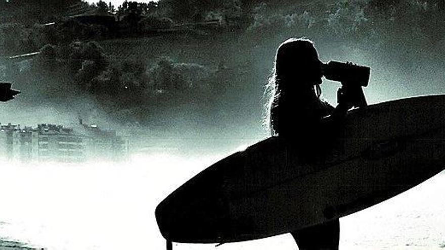 Una joven se refresca tras salir del mar con su tabla de surf.