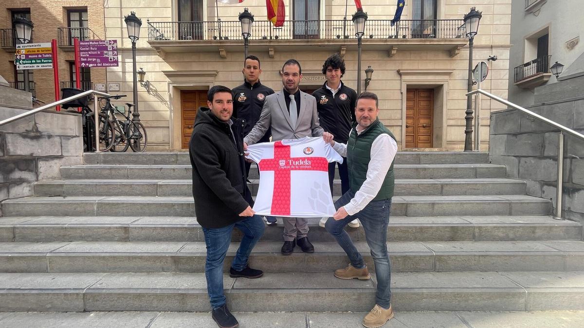 Alcalde y concejal de Deportes presentando con el presidente del Ribera Navarra la camiseta promocionada de 2025.