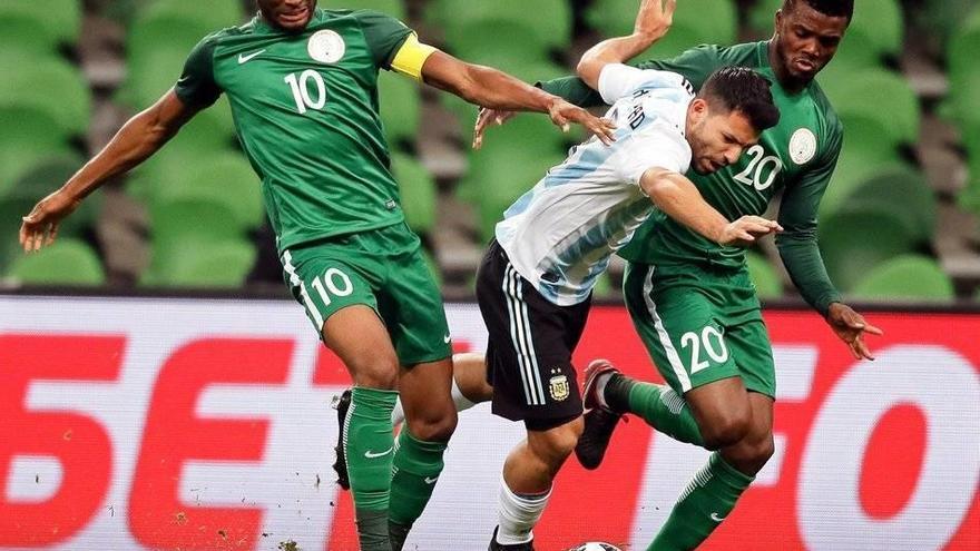 El delantero de la selección argentina Sergio Agüero (c), pelea por el balón contra los jugadores nigerianos John Obi Mikel (i) y Chidozie Awaziem (d), durante el amistoso disputado entre ambas selecciones en Krasnodar (Rusia).