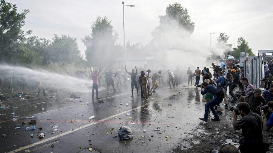 La Policía húngara utiliza gas pimienta y un cañón de agua contra un grupo de refugiados que trató de cruzar la frontera cerca de la frontera con Hungría, cerca de Horgos al norte de Serbia.