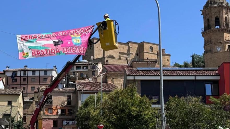 La brigada municipal colocando una pancarta anunciadora de las fiestas