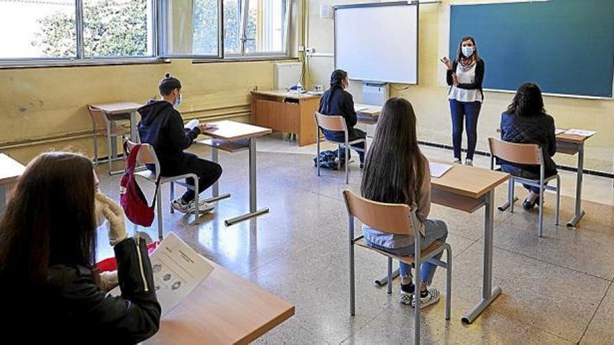 Varios adolescentes siguen la clase con mascarilla