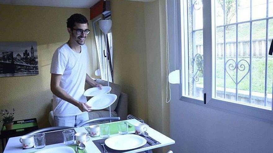 Fernando Servera pone la mesa en el piso en el que vivirá durante este curso en Otxarkoaga. Foto: José Mari Martínez