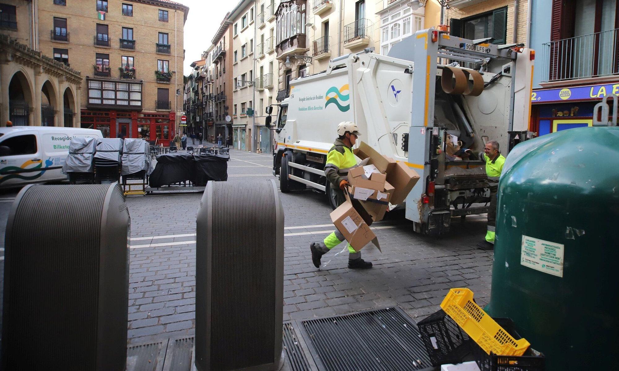 Empleados del servicio de recogida llevándose cajas y bolsas del punto de San Nicolás.