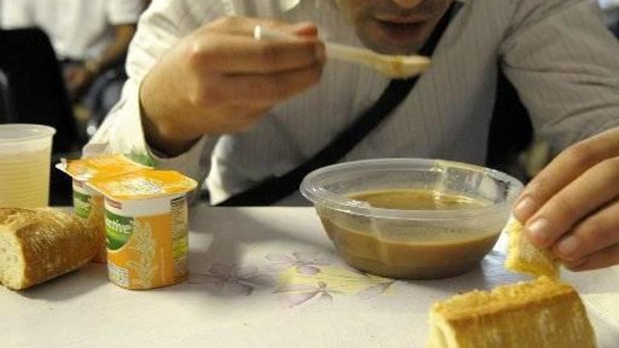 Hombre comiendo en un comedor social.