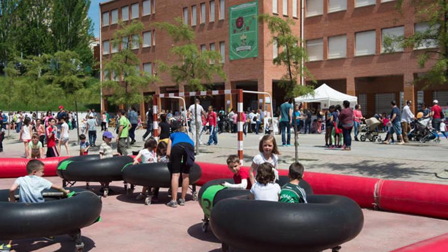 Un grupo de niños jugando bajo el sol con los coches de choque sin motor, una de las actividades instaladas.