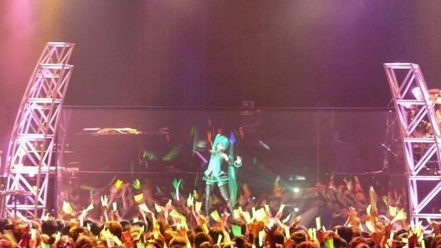 Decenas de fans bailan al ritmo del holograma de Hatsune Miku en un concierto en Japón.
