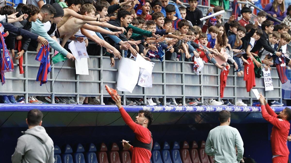 Los jugadores armeros firman autógrafos que siguieron ayer por la tarde el entrenamiento que realizó el Eibar en Ipurua.