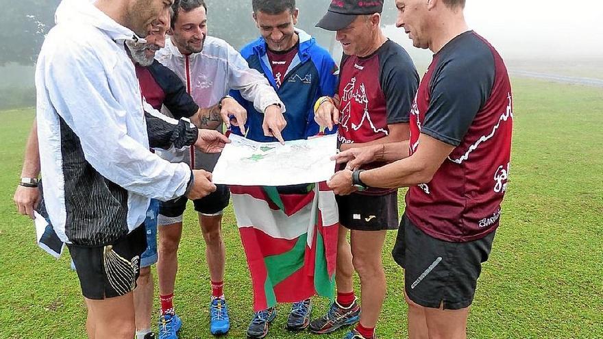 Seis de los ocho participantes consultan un mapa de la comarca en el monte Ilso de Zalla.