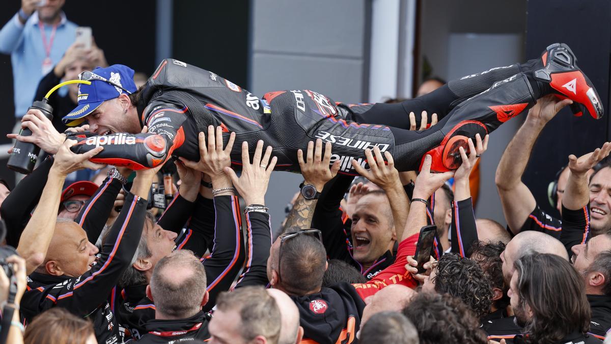 Bezzecchi es jaleado en Cheste por los miembros del equipos Aprilia.