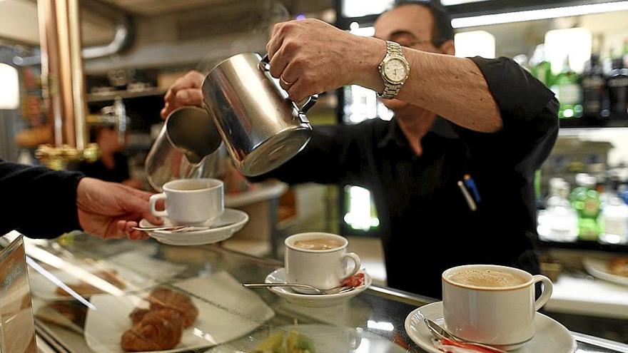 Un camarero sirve un café una establecimiento hostelero.  | FOTO: EFE