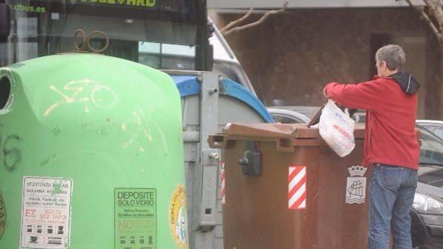 Un ciudadano deposita sus residuos orgánicos en uno de los contenedores marrones instalados en Gros