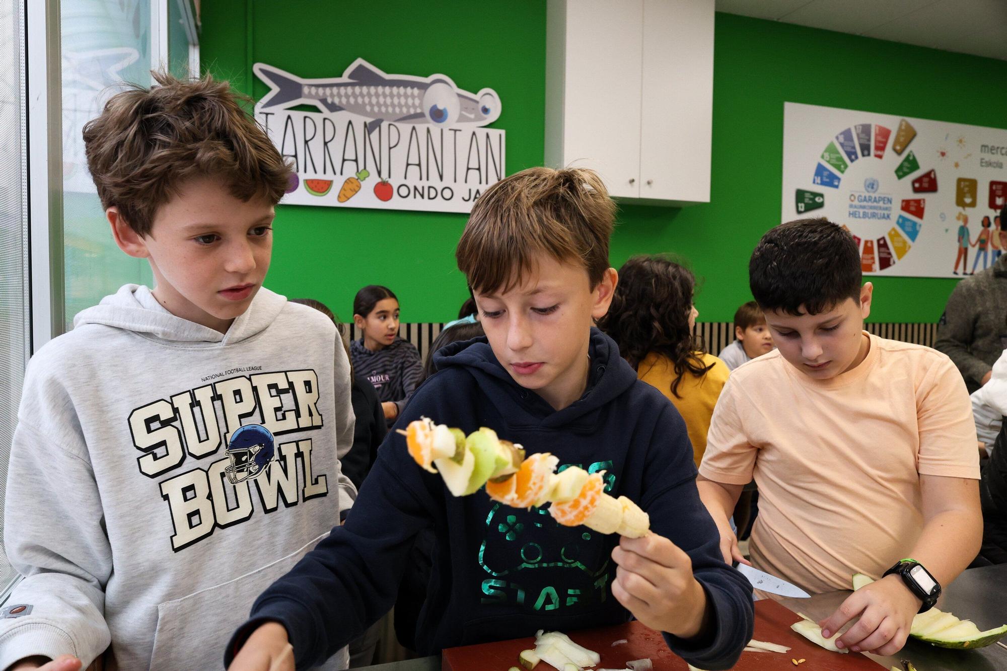 Escolares de San Antonio Ikastetxea de Durango preparan brochetas de frutas en Mercabilbao.