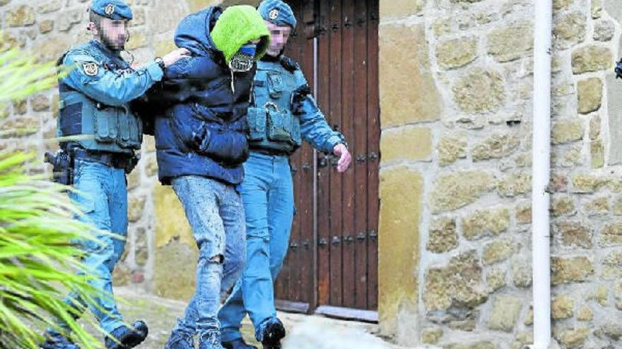 Agentes de la Guardia Civil conducen al joven detenido tras efecutarse el registro de su domicilio. Fotos: Unai Beroiz