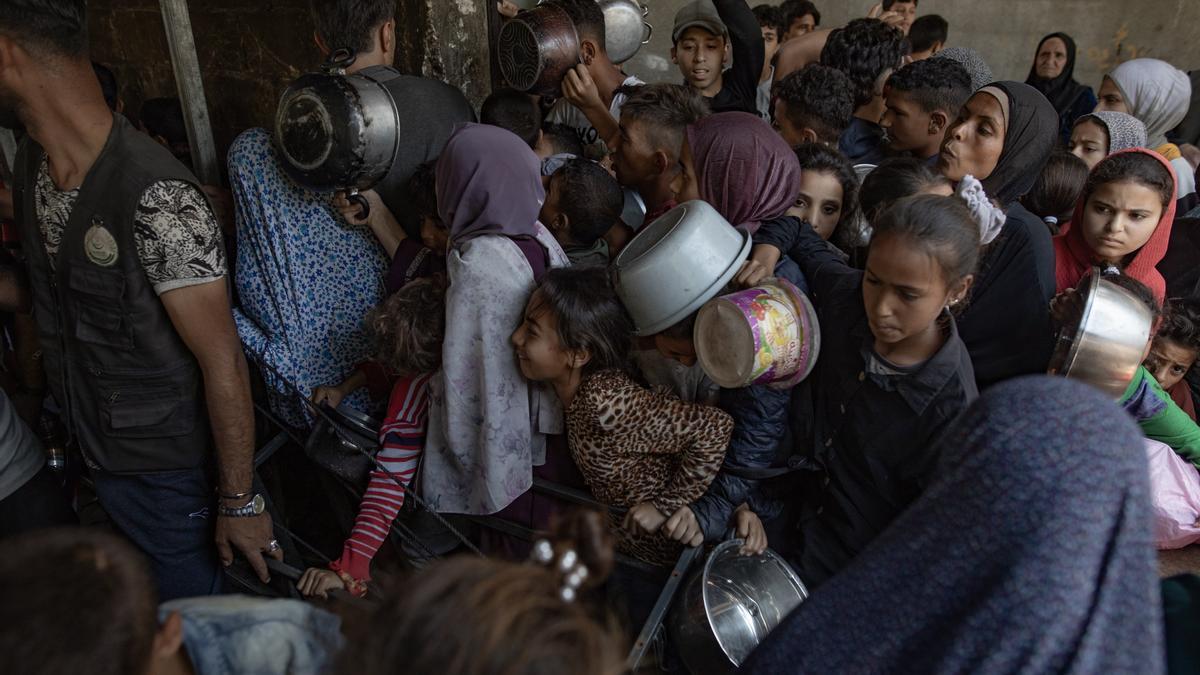 Cientos de palestinos tratando de conseguir una ración de comida.