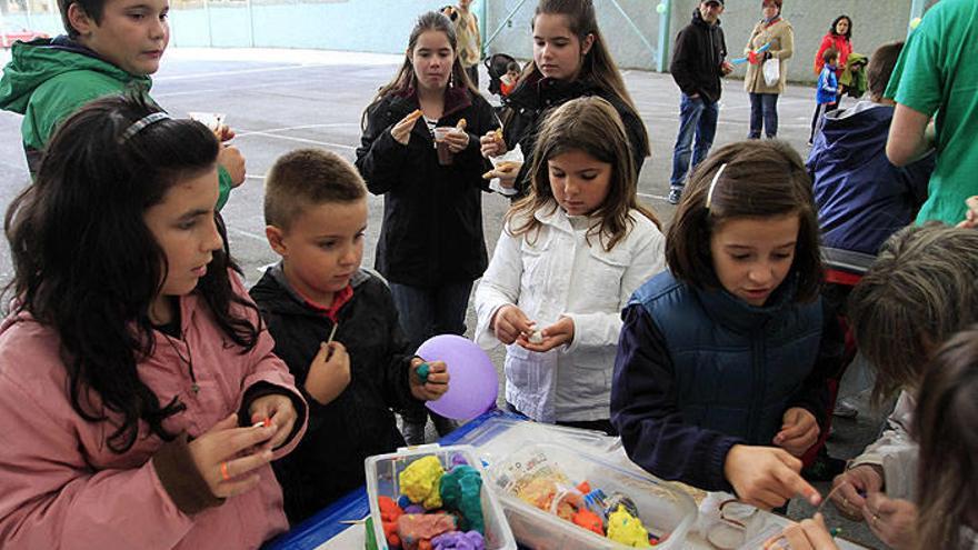 Un grupo de niños juega con plastilina y globos.