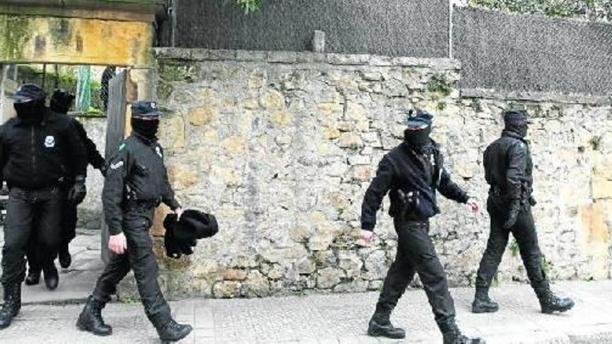 Agentes de la Ertzaintza salen de la vivienda registrada en Algorta, en el marco de una operación europea contra la mafia rusa y georgiana.