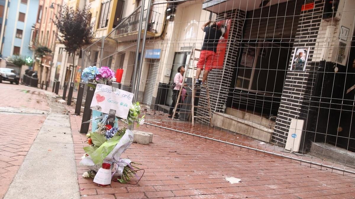 Flores y mensajes de cariño ante el edificio siniestrado.
