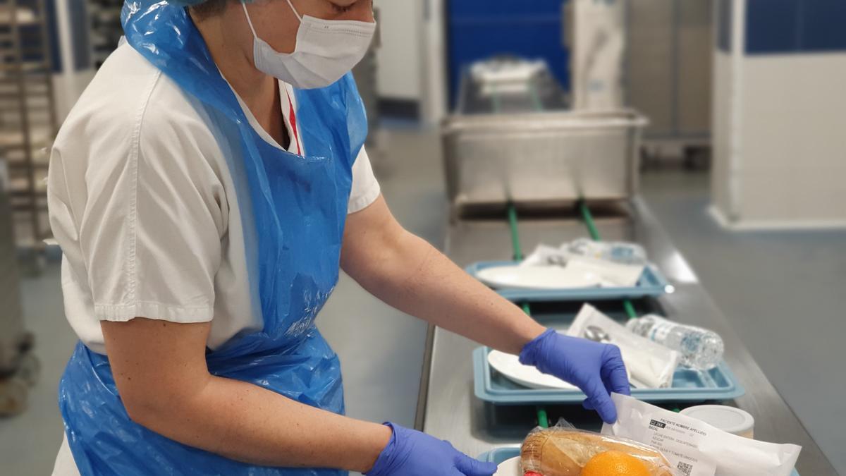 Trabajadora de las cocinas del HUN prepara un desayuno.