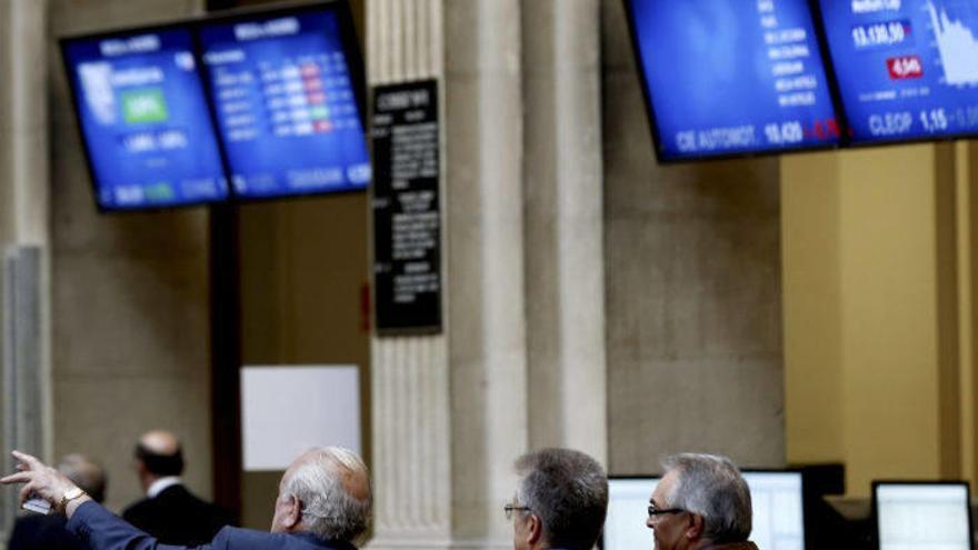 Algunos inversores observan las pantallas que muestran los indicadores del Ibex 35.