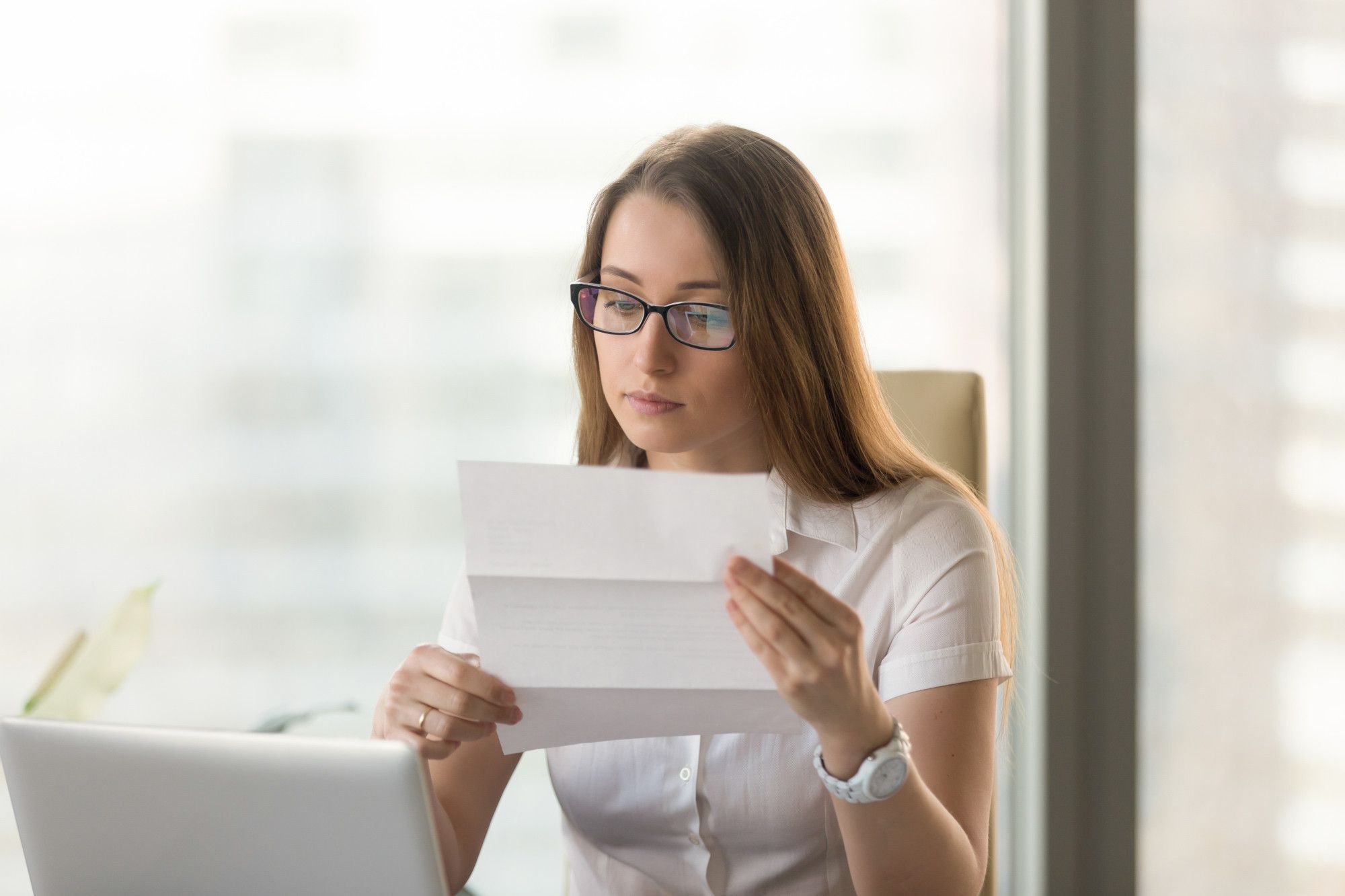 Una mujer lee una carta remitida por su entidad bancaria.