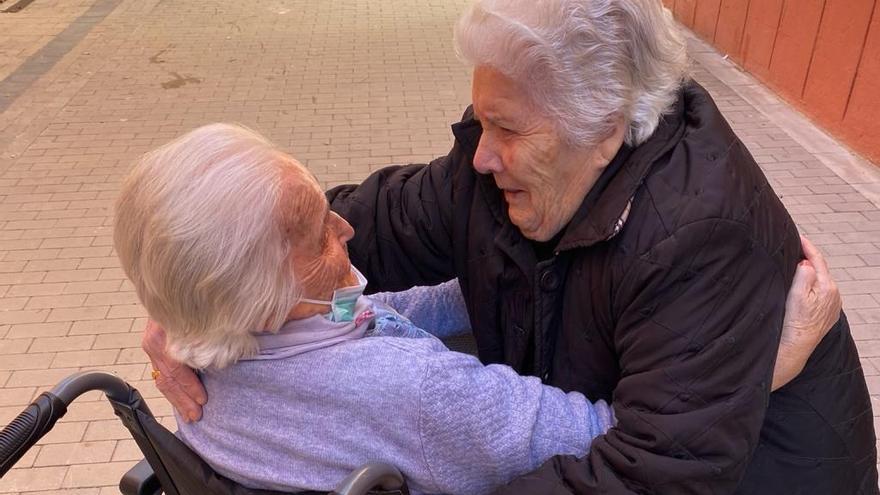 Las dos ancianas, fundiéndose en un emotivo abrazo.