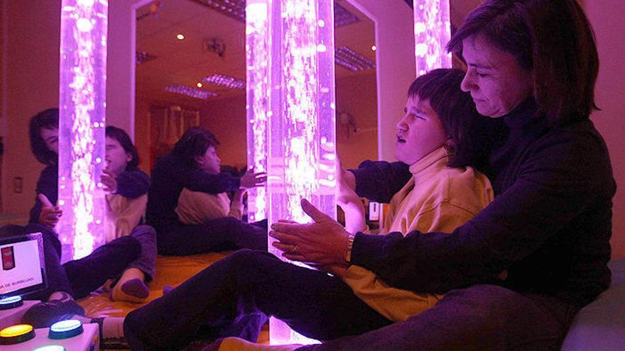 Begoña Irujo trabaja con una alumna en el aula multisensorial. Utiliza la columna de burbujas.